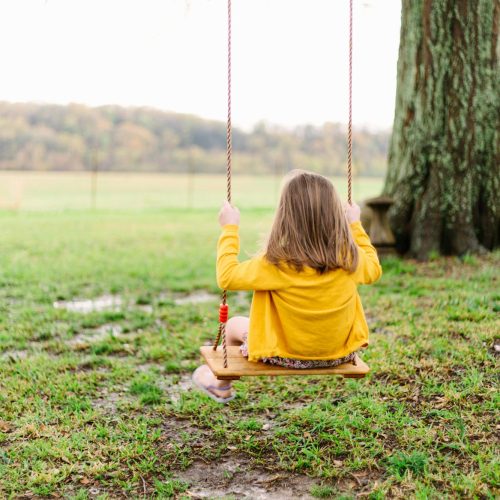 Child swinging on a wooden swing